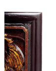 Close-up of dark wood Chinese carvings with gold-painted decorative design on the left side.