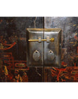 Close-up of ornate metal lock on lacquered wood display cabinet with intricate antique Chinese artwork.