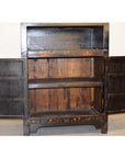 Black display cabinets with floral accents and open shelves, doors open, shown indoors.