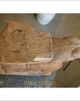 Brown wood Indian guardian lion carvings on circular indoor surface, top view.