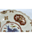 Blue and white porcelain Japanese Imari plates with intricate floral designs and central blue mythical creature, close-up.