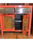 Red bedside cabinets made of wood with open doors and drawers, displayed on a wooden floor, front view.