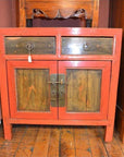 Red vintage bedside cabinets with burl wood drawers and doors on a wooden floor.