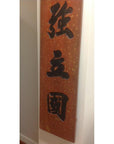 Close-up of a pair of wooden signs with large black Chinese characters, suitable as wall art.