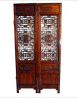 Brown wooden 2-panel screen with open fretwork design, used as a room divider or decorative screen indoors.