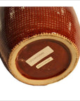 Close-up of the bottom of a white ceramic vase with barcode sticker and Made in Thailand label.