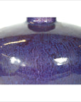 Close-up of deep purple glazed ceramic vase with glossy finish and visible light reflections, very good condition.