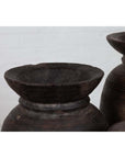 Close-up of brown wooden ghee pots with rustic finish, grouped together, primitive Nepalese style.