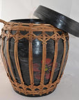 Natural rattan and bamboo lidded basket with woven cover and partially open lid, close-up view.