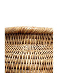 Close-up of neutral rattan square basket, tightly woven top edge visible against a white background.