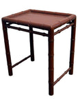 Red bamboo-style side table with reddish-brown finish, featuring bamboo-like legs and edges, close-up view.