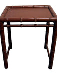 Red bamboo side table with bamboo-inspired legs and edges, shown in close-up against a plain background.
