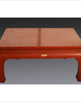 Red lacquer wood low table with vintage chow legs against a gray gradient background.