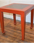 Red side tables with inset floor tile, pair, placed on wooden floor against a white brick wall.