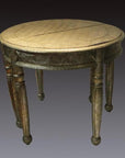 Silver nickel demi-lune table with repousse and carved details, four turned legs, against dark gradient background.