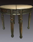 Nickel-silver demi-lune table with repousse design, split in half, set against a dark background.