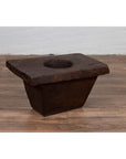 Brown wooden planter on wooden floor next to a white brick wall, rustic and antique style, early 20th century.
