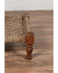 Close-up of brown wood and rope low chair leg on wooden floor.