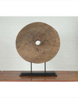 Brown wooden ox cart wheel from Thailand on a black painted base, displayed as decor.