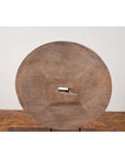 Weathered wood ox cart wheel with square center on black painted base, Thailand, 19th century.
