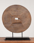 Brown wooden ox cart wheel from Thailand on a black painted base.