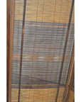 Close-up of light wood window blind with thin horizontal slats and vertical supports, modern design.