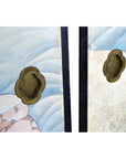 Close-up of two brass handles on vintage Japanese 2-panel screen with fictional character designs.