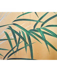 Black and gold 2-panel screen with painted flowers, birds, and bamboo leaves, used as room divider indoors.