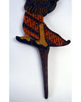 Close-up of painted wooden legs with intricate patterns on three Indonesian Wayang Kulit shadow puppets.