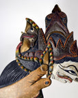 Brown painted wooden Wayang Kulit shadow puppets with stylized faces and ornate headpieces, set of 3.