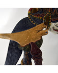 Close-up of three colorful wooden Wayang Kulit shadow puppets with detailed carvings.