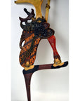 Black and orange wooden Wayang Kulit shadow puppets set of three, ornate costumes, close-up on white background.