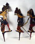 Painted wooden Wayang Kulit Indonesian shadow puppets set of 3 with traditional costumes, close-up on display.
