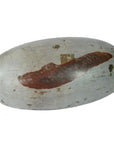 Close-up of an oval gray stone Shiva Lingam with a reddish-brown stripe and worn surface patches.