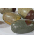 Multicolored oval Shiva Lingam fertility stones, stone material, close-up on white background.