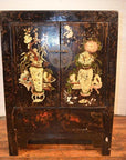 Wood side cabinet with floral vase decorations, round metal handle, placed on a wooden floor, close-up view.