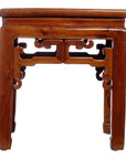Natural wood side table with decorative carved legs and side detailing, shown on a white background.