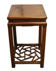 Black metal side table with a square top and geometric cracked ice pattern base shelf, studio view.