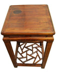Dark wood side table with geometric cracked ice base and visible dark stain mark on the top surface, close-up view.