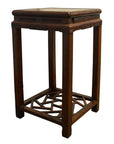 Wooden side table with decorative carvings and geometric cracked ice base, close-up view.