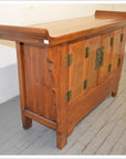 Wooden sideboard with everted flanges, metal hinges and handles, raised back edge, and paneled doors.