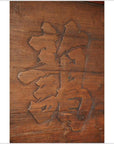 Close-up of a wooden signboard featuring a carved Chinese dragon (龙/龍) character.