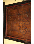 Brown wooden signboard with inscribed text.