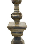 Close-up of a silver plated candle holder with square base and rounded decorative details.