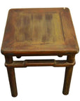 Natural elm wood table or stool with four legs and a slightly worn finish, close-up.
