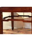 Close-up of light wood square table legs with curved stretcher, on wood floor against a light background.