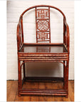 Brown bamboo and elm horseshoe-back armchair on wooden floor against a white wall indoors.