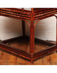 Brown bamboo and elm horseshoe-back armchair next to bamboo side table, lower half view indoors.