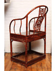 Brown bamboo and elm horseshoe-back armchair on a wooden floor indoors, 19th century Chinese style.