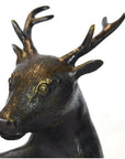 Close-up of bronze deer sculpture with detailed antlers and textured fur.